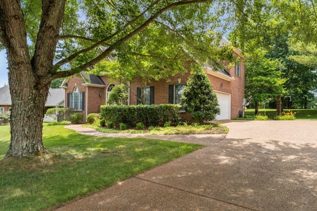 7125 Locksley Ln, Fairview, TN 37062 - view of property hidden behind natural elements featuring an attached garage, concrete driveway, brick siding, and a front yard