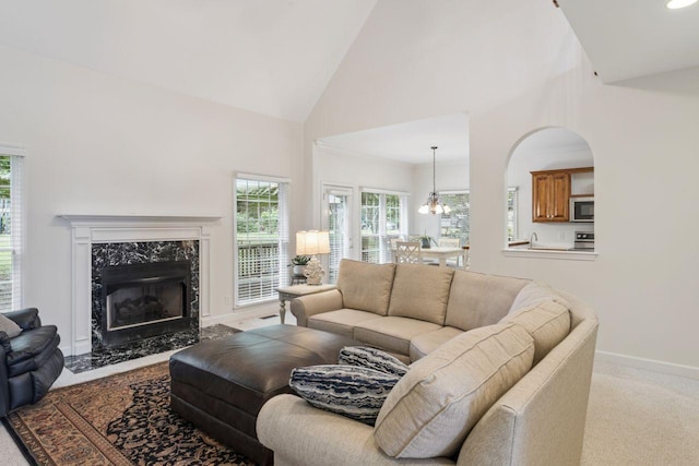 7125 Locksley Ln, Fairview, TN 37062 - carpeted living area featuring a chandelier, high vaulted ceiling, and a premium fireplace