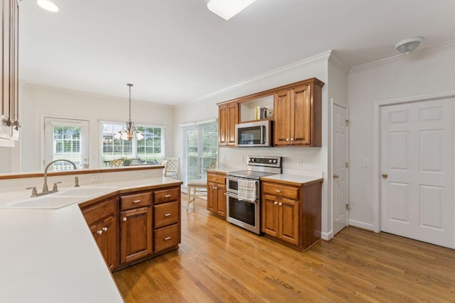 7125 Locksley Ln, Fairview, TN 37062 - kitchen featuring appliances with stainless steel finishes, brown cabinets, crown molding, and light wood-style floors