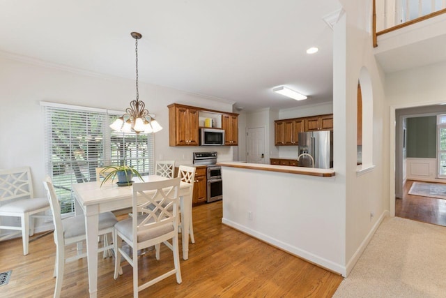 7125 Locksley Ln, Fairview, TN 37062 - dining room with healthy amount of natural light, a chandelier, crown molding, light wood finished floors, and arched walkways