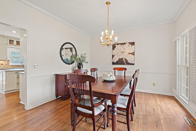 513 Foxcroft Cir, Franklin, TN 37067 - dining area with crown molding, a chandelier, and light wood finished floors