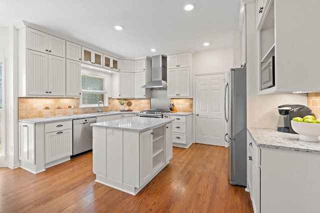 513 Foxcroft Cir, Franklin, TN 37067 - kitchen featuring wall chimney exhaust hood, open shelves, appliances with stainless steel finishes, light wood-style floors, and a kitchen island