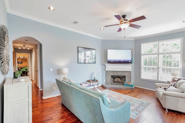3045 Sakari Cir, Spring Hill, TN 37174 - living room featuring a ceiling fan, arched walkways, wood finished floors, a stone fireplace, and crown molding