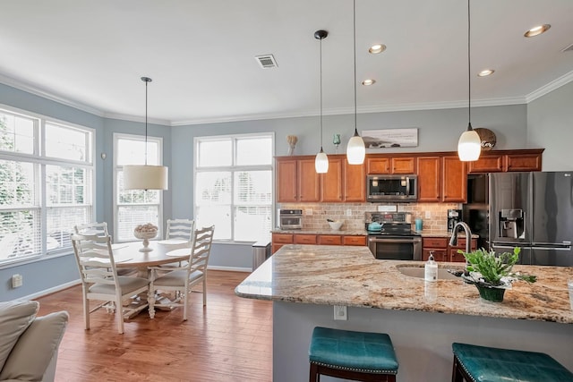 3045 Sakari Cir, Spring Hill, TN 37174 - kitchen with stainless steel appliances, ornamental molding, brown cabinets, plenty of natural light, and tasteful backsplash