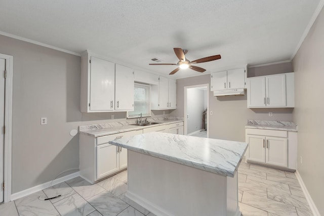 274 Spring Hill Rd, Stanton, TN 38069 - kitchen with light marble finish flooring, ceiling fan, white cabinets, crown molding, and a center island