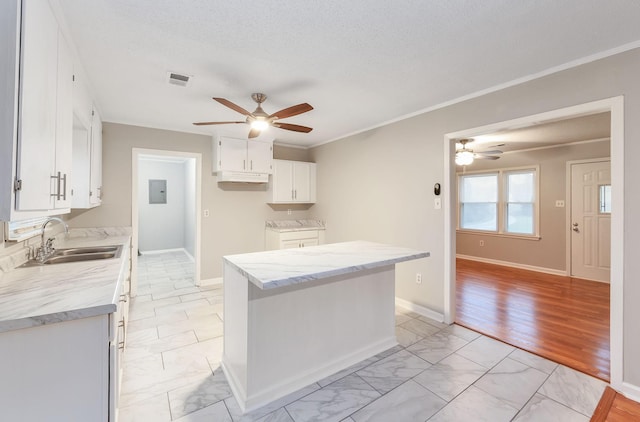 274 Spring Hill Rd, Stanton, TN 38069 - kitchen with ceiling fan, light marble finish flooring, white cabinets, crown molding, and a textured ceiling