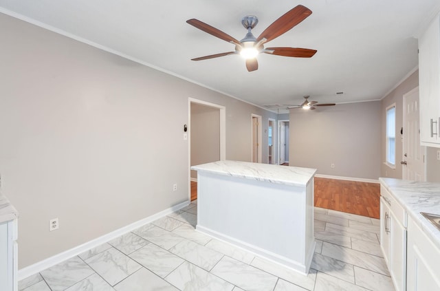 274 Spring Hill Rd, Stanton, TN 38069 - kitchen with light marble finish flooring, ceiling fan, crown molding, white cabinetry, and light stone counters