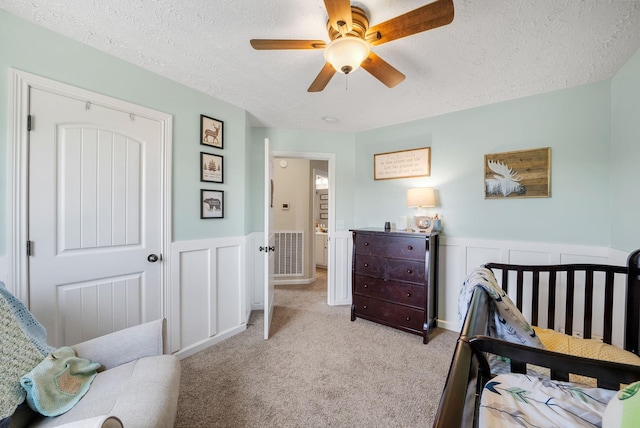 2210 Indian Mound Rd, Woodlawn, TN 37191 - bedroom with a textured ceiling, light colored carpet, a wainscoted wall, a decorative wall, and a ceiling fan