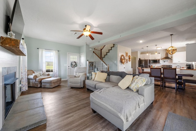 2210 Indian Mound Rd, Woodlawn, TN 37191 - living room with a tiled fireplace, stairway, dark wood-style floors, and a ceiling fan