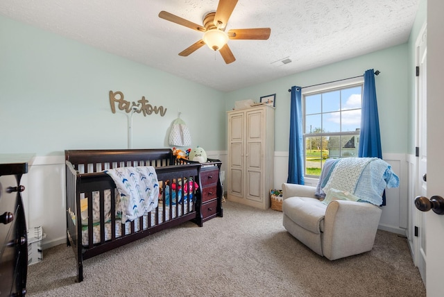 2210 Indian Mound Rd, Woodlawn, TN 37191 - bedroom featuring light colored carpet, wainscoting, ceiling fan, a textured ceiling, and a nursery area