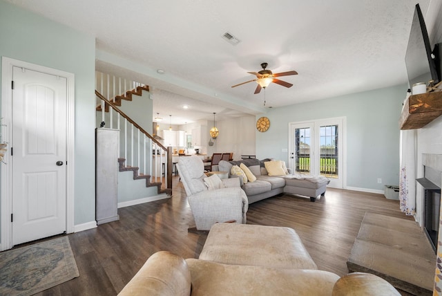 2210 Indian Mound Rd, Woodlawn, TN 37191 - living room featuring stairs, dark wood-style flooring, a ceiling fan, and a glass covered fireplace