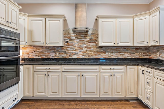 1011 Glessner Dr, Spring Hill, TN 37174 - kitchen with wall chimney exhaust hood, stainless steel double oven, black electric cooktop, backsplash, and ornamental molding