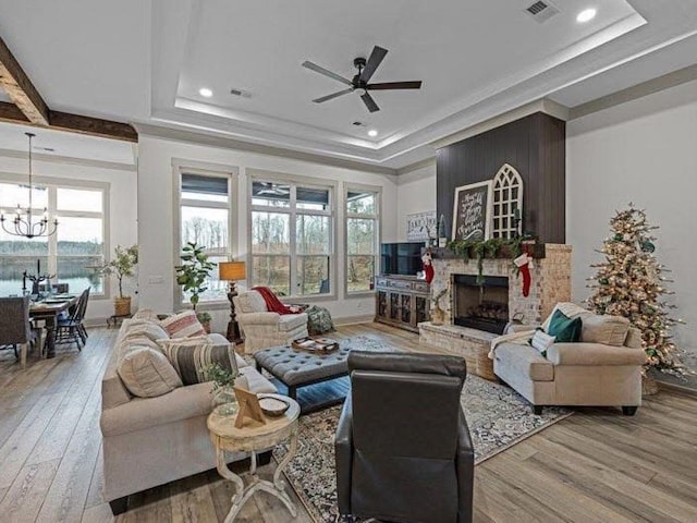 25 Shoreview Ln, Huntingdon, TN 38344 - living area featuring hardwood / wood-style floors, a tray ceiling, a fireplace, ceiling fan, and a chandelier