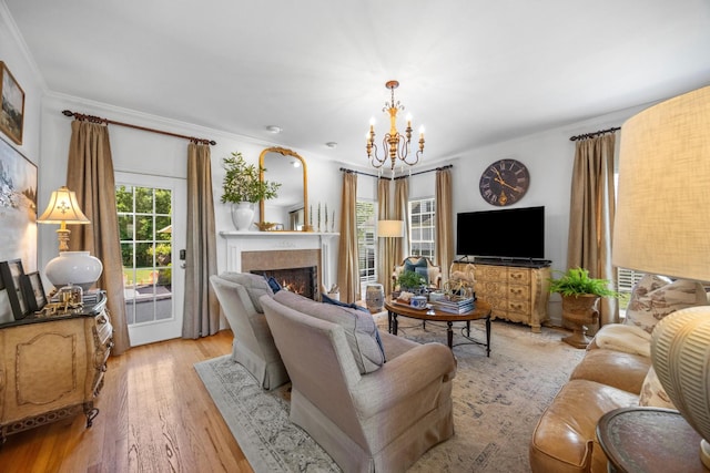 7767 Lynnle Way, Hixson, TN 37343 - living room with a chandelier, a lit fireplace, ornamental molding, and light wood-style floors