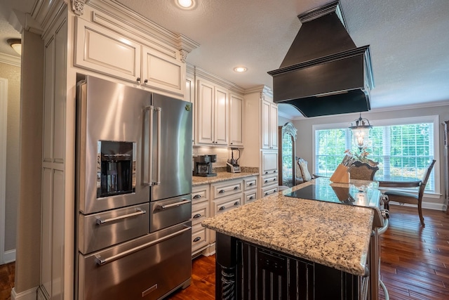 130 Fairway Cir, Loretto, TN 38469 - kitchen with high quality fridge, cream cabinets, custom exhaust hood, light stone countertops, and crown molding