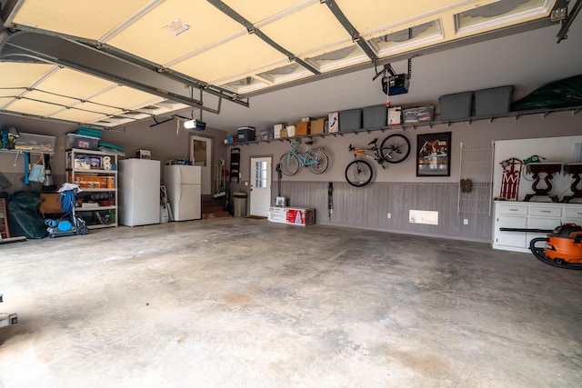 130 Fairway Cir, Loretto, TN 38469 - garage with freestanding refrigerator, refrigerator, and a garage door opener