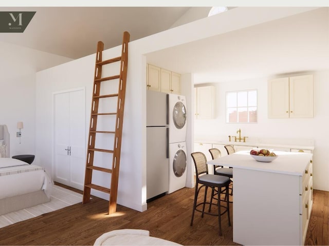 1572 Madison St, Chattanooga, TN 37408 - kitchen with stacked washing machine and dryer, freestanding refrigerator, wood finished floors, a breakfast bar, and light countertops