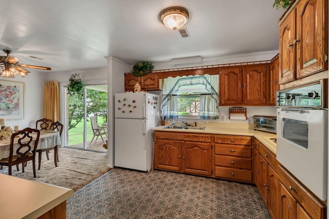 5007 Olivia Dr, Antioch, TN 37013 - kitchen with white appliances, healthy amount of natural light, brown cabinets, light countertops, and crown molding