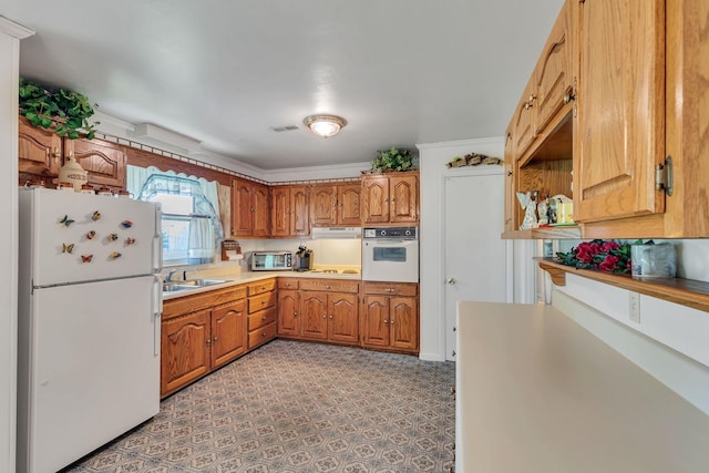 5007 Olivia Dr, Antioch, TN 37013 - kitchen with white appliances, brown cabinetry, and light countertops