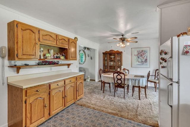 5007 Olivia Dr, Antioch, TN 37013 - kitchen featuring freestanding refrigerator, ceiling fan, light countertops, ornamental molding, and brown cabinets