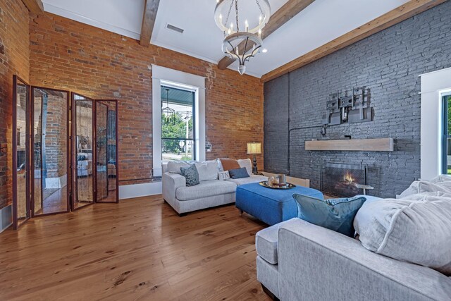 422 N Academy St, Murfreesboro, TN 37130 - living room featuring beamed ceiling, a chandelier, wood finished floors, a stone fireplace, and a high ceiling