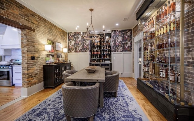 422 N Academy St, Murfreesboro, TN 37130 - wine room with a wainscoted wall, wood finished floors, a chandelier, ornamental molding, and bar