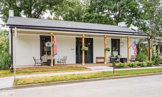 422 N Academy St, Murfreesboro, TN 37130 - view of front of house featuring a chimney, covered porch, a shingled roof, and brick siding