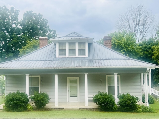 8 Brush Creek Rd, Brush Creek, TN 38547 - view of front of house featuring a chimney, a porch, and a metal roof