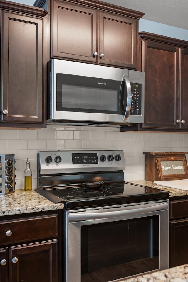 15252 Foamflower Ln, Sale Creek, TN 37373 - kitchen featuring appliances with stainless steel finishes, dark brown cabinetry, backsplash, and light stone countertops