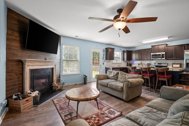 15252 Foamflower Ln, Sale Creek, TN 37373 - living room featuring a ceiling fan, wood finished floors, and a fireplace with raised hearth