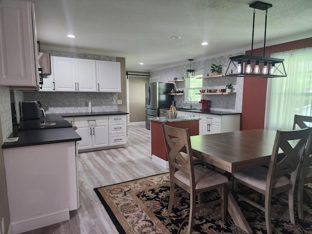 119 Horn Ave, Loretto, TN 38469 - kitchen with freestanding refrigerator, crown molding, light wood-type flooring, dark countertops, and white cabinetry