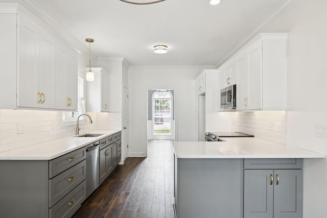 1704 Satterfield Ct, Murfreesboro, TN 37128 - kitchen with gray cabinetry, appliances with stainless steel finishes, a peninsula, light countertops, and crown molding