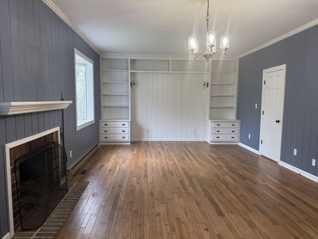 236 N Carolina Ave, Sewanee, TN 37375 - unfurnished living room featuring crown molding, dark wood finished floors, a fireplace, a chandelier, and wooden walls