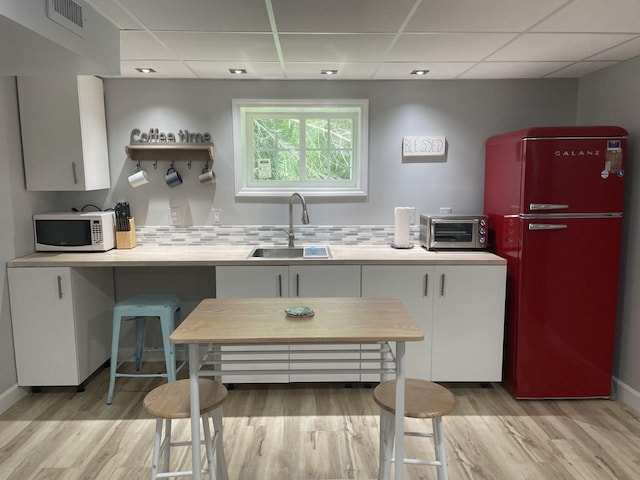 236 N Carolina Ave, Sewanee, TN 37375 - kitchen featuring white microwave, a paneled ceiling, light wood finished floors, white cabinets, and light countertops