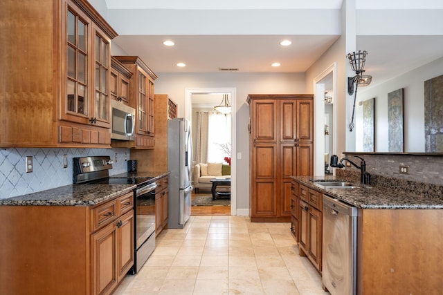 6853 Manassas Gap Ln, Hixson, TN 37343 - kitchen featuring stainless steel appliances, backsplash, brown cabinetry, glass insert cabinets, and recessed lighting