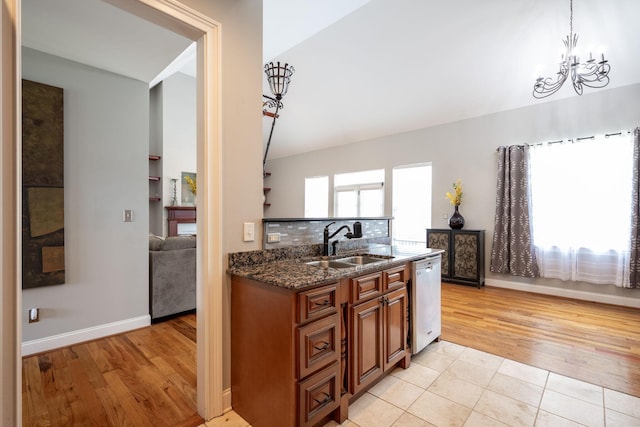 6853 Manassas Gap Ln, Hixson, TN 37343 - kitchen featuring dishwasher, brown cabinetry, dark stone counters, a chandelier, and vaulted ceiling