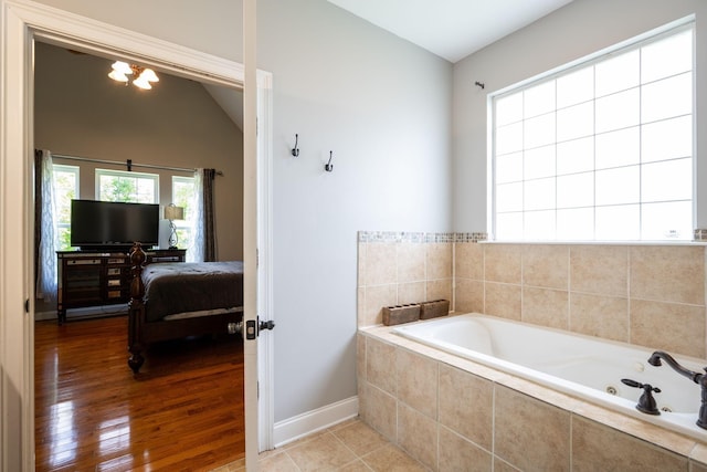 6853 Manassas Gap Ln, Hixson, TN 37343 - bathroom featuring a whirlpool tub, wood finished floors, vaulted ceiling, and ensuite bathroom