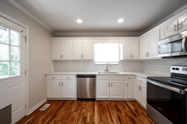 270 Autumn Trl, Ringgold, GA 30736 - kitchen with stainless steel appliances, white cabinets, decorative backsplash, dark wood finished floors, and crown molding