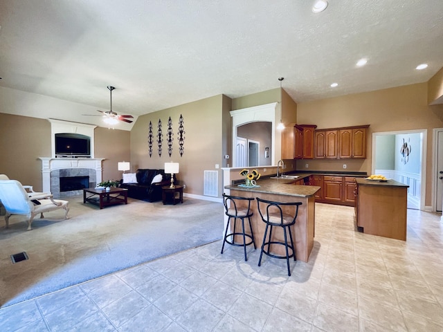 2714 Maylon Dr, Murfreesboro, TN 37128 - kitchen with light carpet, a peninsula, brown cabinetry, dark countertops, and open floor plan