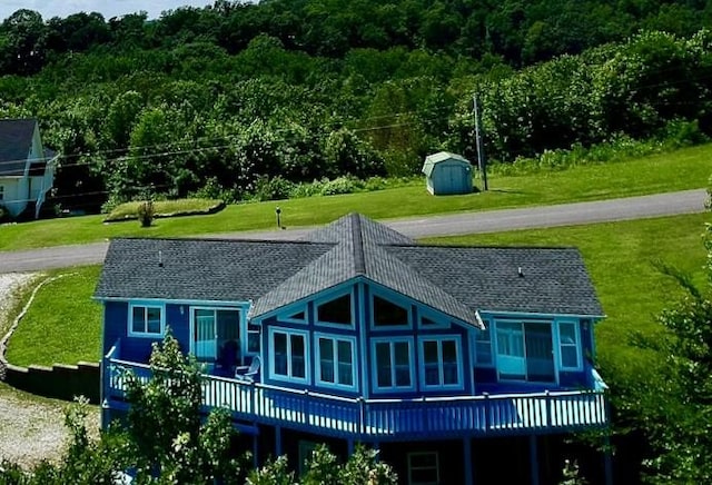 465 Turtle Point Ln, Waverly, TN 37185 - rear view of house with a storage unit, a deck, a wooded view, and a lawn
