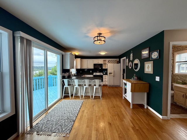 465 Turtle Point Ln, Waverly, TN 37185 - kitchen featuring white appliances, a peninsula, light wood-type flooring, and a kitchen bar