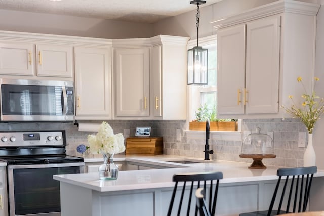 108 Larry Joe Pl, Portland, TN 37148 - kitchen featuring stainless steel appliances, light countertops, white cabinetry, and backsplash