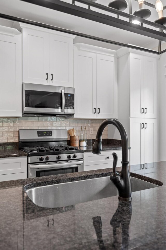 3767 Lee Pike, Soddy Daisy, TN 37379 - kitchen with appliances with stainless steel finishes, white cabinetry, decorative backsplash, and dark stone counters