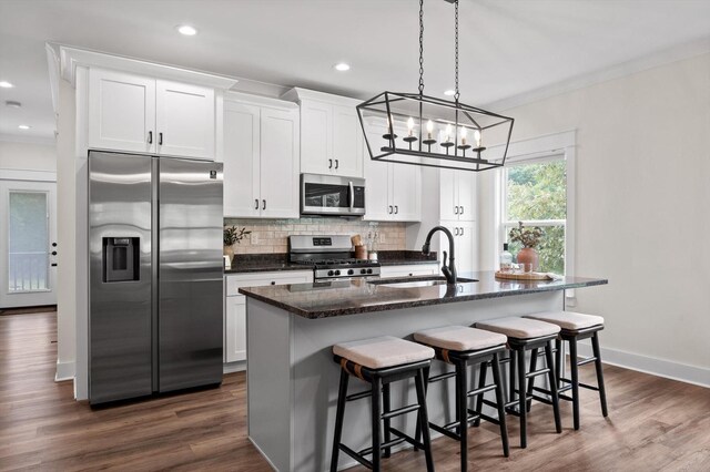 3767 Lee Pike, Soddy Daisy, TN 37379 - kitchen with stainless steel appliances, a kitchen island with sink, decorative backsplash, a chandelier, and white cabinetry