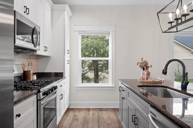 3767 Lee Pike, Soddy Daisy, TN 37379 - kitchen with stainless steel appliances, light wood-style floors, decorative backsplash, and dark stone countertops