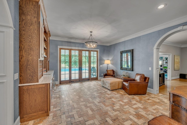 2485 Old Natchez Trce, Franklin, TN 37069 - living area featuring arched walkways, brick flooring, french doors, ornamental molding, and a chandelier