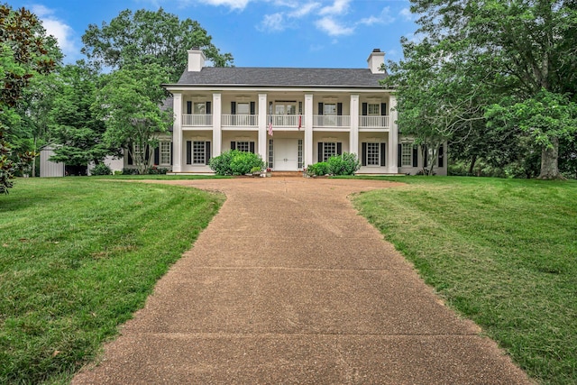 2485 Old Natchez Trce, Franklin, TN 37069 - neoclassical home featuring a chimney, a balcony, a front yard, driveway, and an outdoor structure