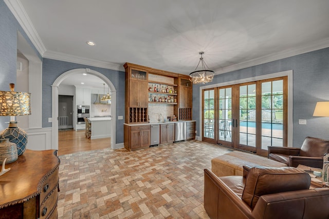 2485 Old Natchez Trce, Franklin, TN 37069 - living area with bar area, french doors, arched walkways, a chandelier, and brick patterned flooring