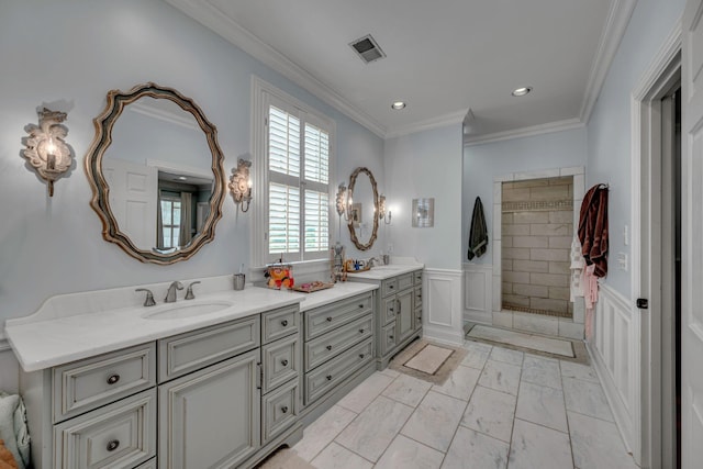 2485 Old Natchez Trce, Franklin, TN 37069 - bathroom featuring double vanity, a decorative wall, tiled shower, ornamental molding, and a wainscoted wall