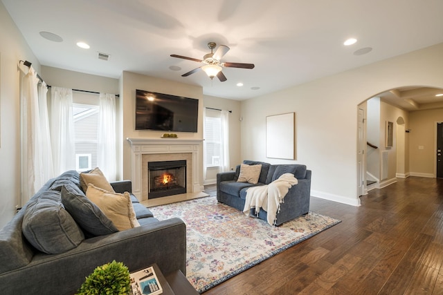222 Fowler Cir, Franklin, TN 37064 - living area featuring arched walkways, ceiling fan, a fireplace with flush hearth, dark wood finished floors, and stairway